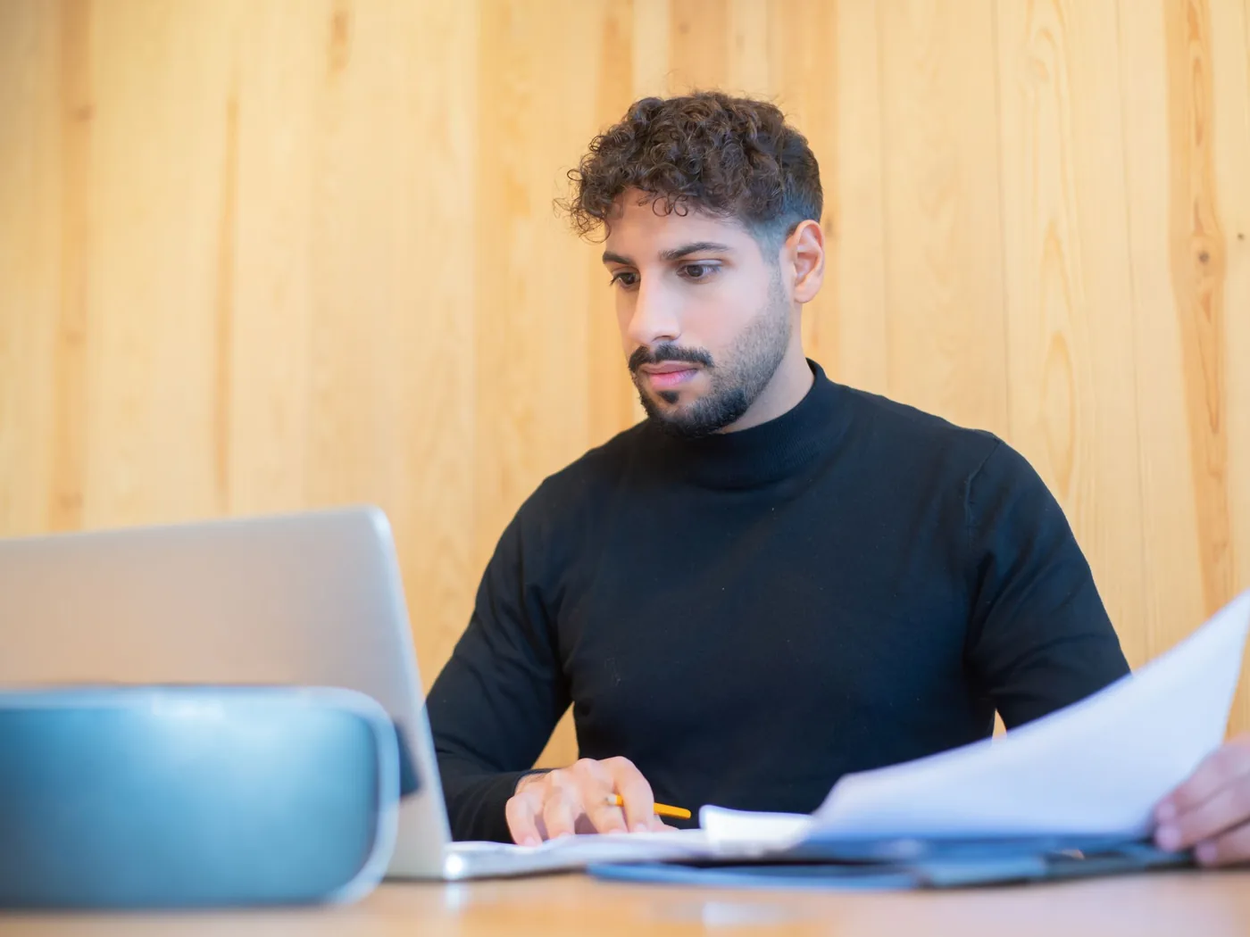 Un dirigeant de petite entreprise traite ses documents devant son ordinateur portable
